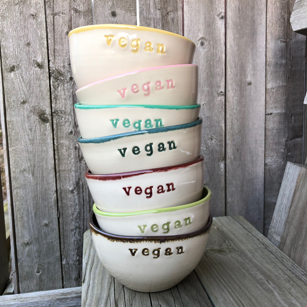 Stacked ceramic bowls with the word vegan stamped on them
