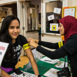 a volunteer at a check-in table at Boston Veg Food Fest 2016