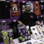 exhibitor poses at table