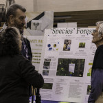 exhibitor talks with attendees about forests