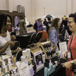 exhibitor talks with attendees about products