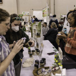 exhibitor talks with attendees about products