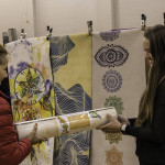 exhibitor talks with attendees about products