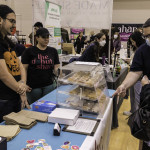 exhibitor talks with attendees about products