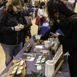 exhibitor talks with attendees about products