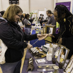 exhibitor talks with attendees about products