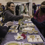 exhibitor gives an attendee a food sample