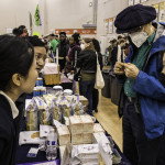 exhibitor talks with attendees about products