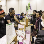 exhibitor talks with attendees about products