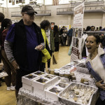exhibitor talks with attendees about products