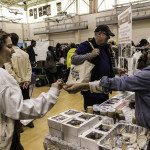 exhibitor talks with attendees about products
