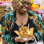 Attendee at Boston Veg Food Fest 2024 holding a box of vegan food and smiling
